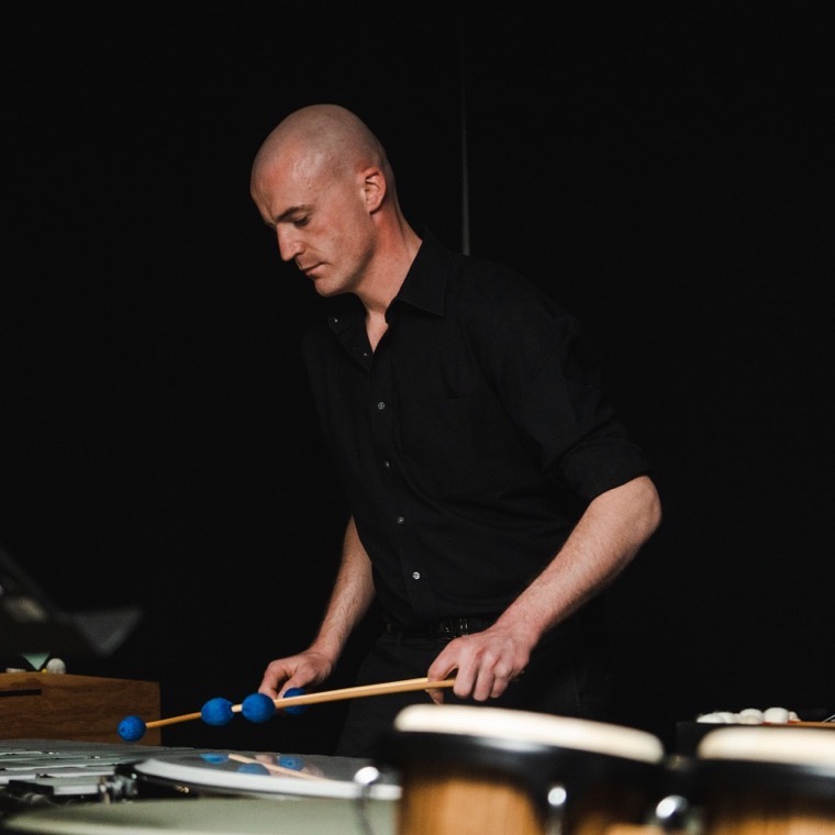 Dennis Vanhove aan de vibrafoon met blauwe mallets; op de voorgrond staan pauken.